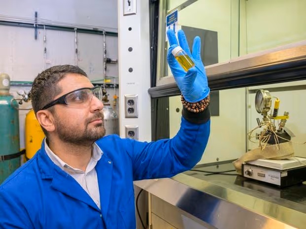 Delaware Üniversitesi'nde kimya ve biyomoleküler mühendisliği alanında doktora adayı olan Ali Kamali, plastiklerden üretilen bir sıvı yakıt örneğini inceliyor. Kamali, plastik atıkların sıvı yakıtlara dönüşümünü mevcut yöntemlere göre daha hızlı ve daha az istenmeyen yan ürünle artıran yeni bir katalizör türü geliştiren UD liderliğindeki bir araştırma ekibinin parçası.